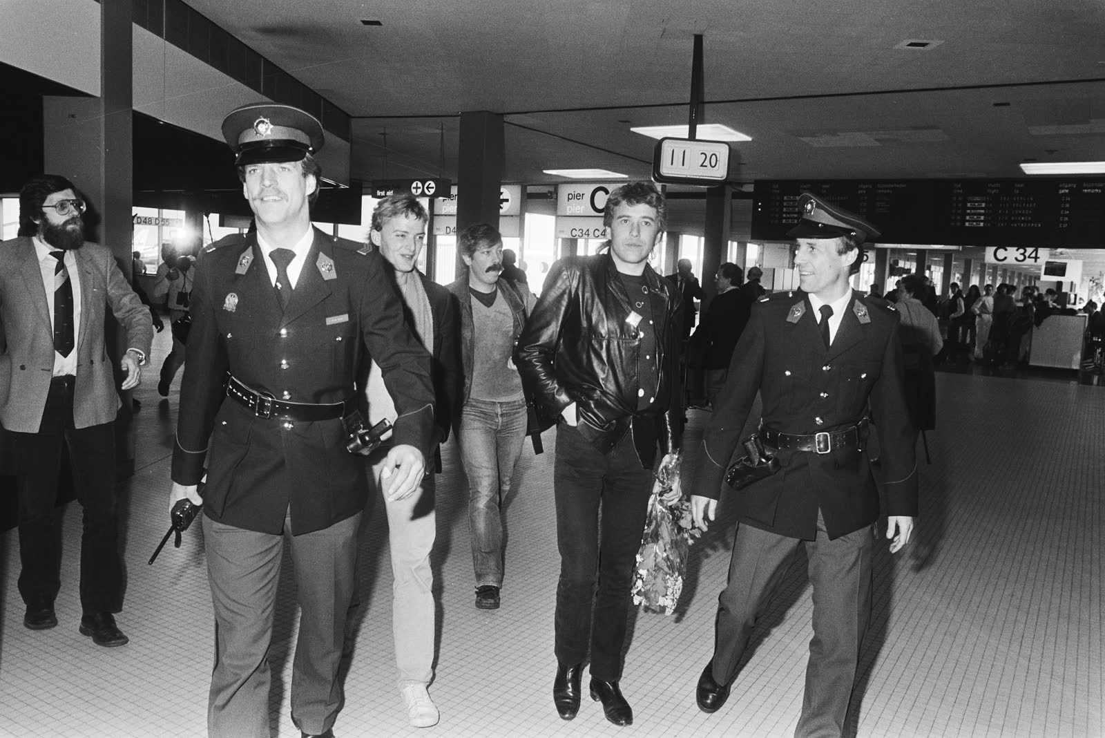 George Kooymans tussen douaniers op Schiphol, april 1983.